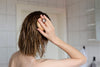 woman brushing her hair after taking a bath